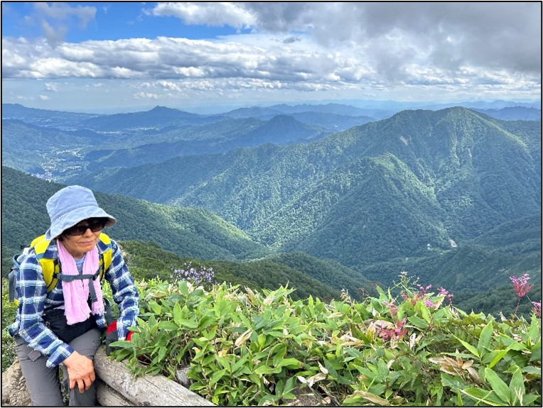 山々と休憩中の登山者